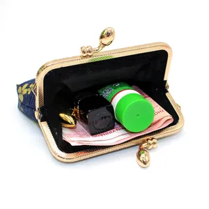 Detail view of floral fabric coin purse showing internal storage for lipstick and cash
