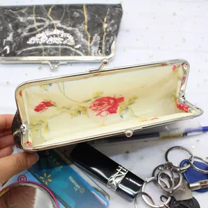 Detail view of marble pattern coin purse showing interior storage for lipstick and cards