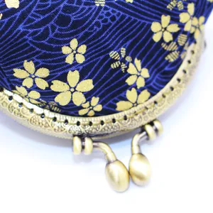 Close-up of Japanese fabric coin purse with gold sakura pattern and vintage metal clasp