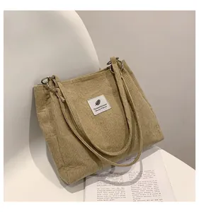 Detail of khaki corduroy tote bag showing vertical texture and stylish white fabric label