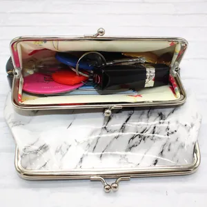 Macro detail of marble pattern coin purse showing silver clasp and floral lining