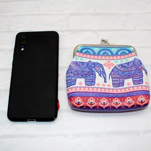 Etnische olifant portemonnee met boho-patroon naast een telefoon voor de schaalvergroting
