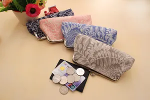 Detail of four fabric kiss-lock coin purses with leaf patterns in various soft colors