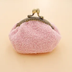 Gros plan du porte-monnaie en peluche rose avec fermoir rétro en bronze gravé de fleurs