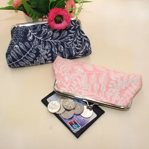 Detailed view of navy and pink canvas coin purses with leaf patterns and metal clasps