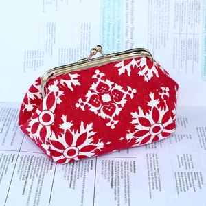Gros plan détaillé d'un porte-monnaie ethnique rouge avec motifs blancs et fermoir doré