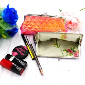 Detail of laser fish scale coin purse with floral lining and metal kiss-lock closure