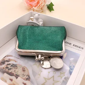 Close-up of green grid textured mini coin purse with classic silver kiss-lock closure