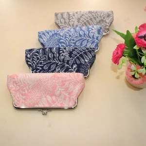 Close-up of four floral canvas coin purses with metal kiss-lock and leaf patterns