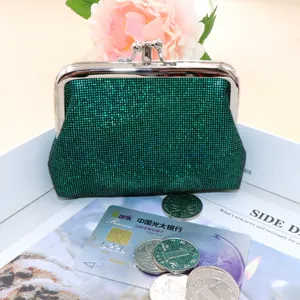 Macro shot of green sequin coin purse with vintage metal frame on white display tray