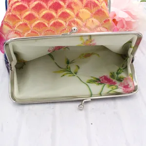 Detail of laser fish scale coin purse with floral fabric lining and silver metal clasp