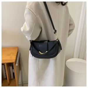 Side view of black crescent saddle bag with gold metal buckle and adjustable strap