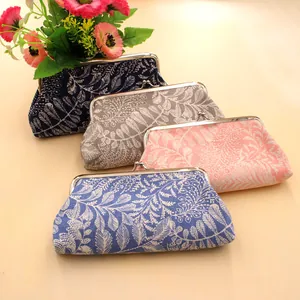 Close-up of vintage canvas coin purses with leaf patterns and silver metal clasps