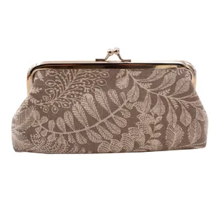 Detail of vintage canvas coin purse showing leaf jacquard fabric and golden kiss-lock