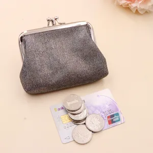 Macro detail of a vintage shiny silver coin purse with kiss-lock and coins on a white background