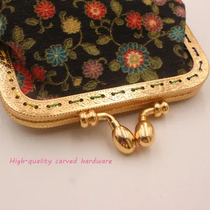 Macro detail of high-quality carved gold hardware on a vintage floral fabric coin purse
