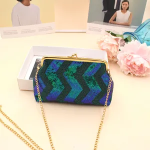 Macro detail of teal sequin wavy pattern with golden metal clasp on mini bag