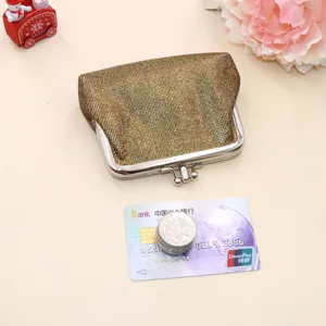 Close-up of golden metallic mesh coin purse with classic silver kiss-lock frame and coins