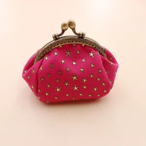 Macro detail of rose red corduroy coin purse with gold star prints and embossed metal clasp