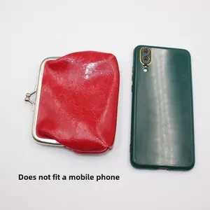 Retro red oil wax PU leather kiss-lock coin purse shown next to phone for size scale