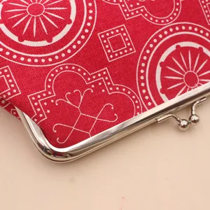 Detail of red floral canvas purse featuring a vintage silver metal kiss-lock clasp closure