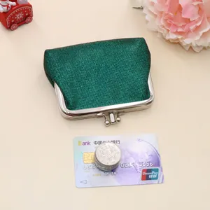 Close-up of vintage dark green glitter coin purse with silver metal kiss-lock closure