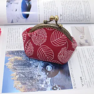 Detailed embroidery on vintage red canvas purse with bronze leaf clasp closure