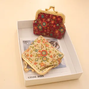 Detail of vintage fabric coin purses with floral patterns and ornate gold metal clasps