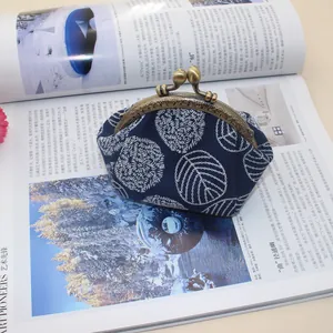 Detailed view of the vintage metal clasp and leaf pattern on this canvas frame coin purse
