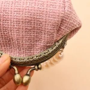 Roze tweed tasje met bronzen metalen frame en elegante parelmoer handgreep