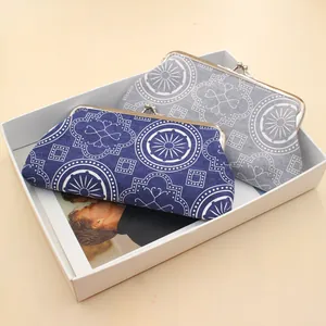Detailed view of canvas clutch bags with mandala patterns and silver metal clasps