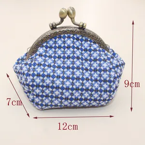Macro-opname van vintage stoffen tas met bronzen kiss-lock en 12 cm breedte formaat