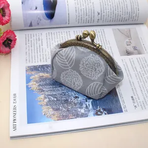 Close-up of retro canvas coin purse with leaf print and bronze kiss-lock clasp