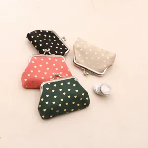 Set of four vintage kiss-lock coin pouches with golden heart patterns in varied colors