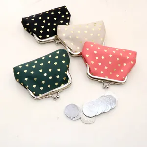 Detail view of four vintage fabric coin purses with golden heart patterns and metal clasps