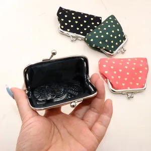 Detail of vintage fabric coin purses with gold heart prints and metal kiss-lock closures