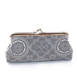 Detailed view of grey geometric canvas clutch featuring vintage metal frame and clasp