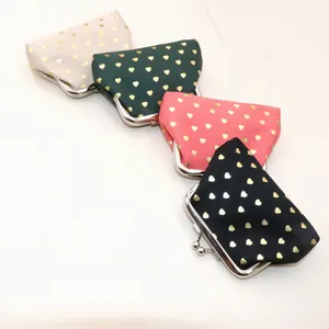 Detail of four fabric coin purses with gold heart patterns and metal kiss-lock closure