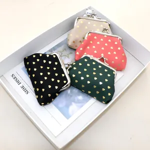Close-up of fabric coin purses with gold heart patterns and classic kiss-lock metal clasps