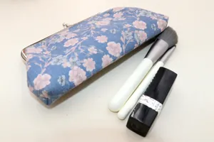 Detail of vintage floral fabric pouch with silver metal kiss-lock frame closure