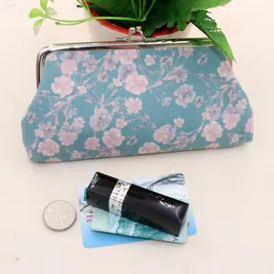 Detail view of vintage floral fabric pouch with metal clasp showing texture and size