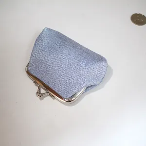 Gros plan d'un petit porte-monnaie bleu pailleté avec fermoir clic-clac en métal