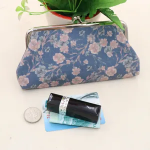 Size comparison of a vintage floral fabric wallet with daily essentials like coins
