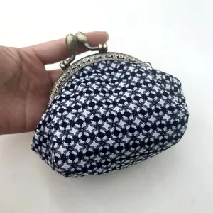 Detailopname van een hand die een zwart-witte houndstooth tweed knipbeurs vasthoudt
