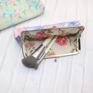 Detail van laser glitter make-up tasje met bloemenvoering en diverse make-up kwasten