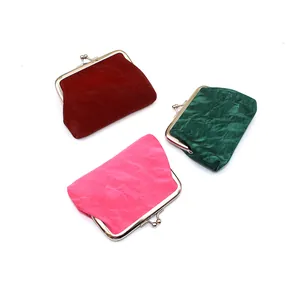 Detailopname van vintage kiss-lock portemonnees in fluwelen bordeaux, groen en roze