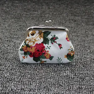 Detail of vintage canvas coin purse with red rose floral print and silver kiss-lock