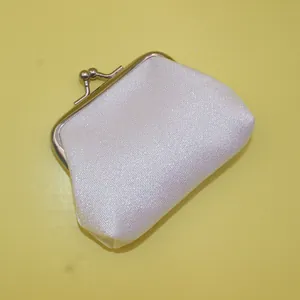 Détail du tissu blanc scintillant irisé et du fermoir métallique argenté du porte-monnaie