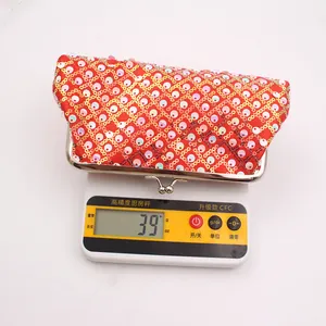 Detail van een rode pailletten clutch met een gewicht van 39g op een digitale weegschaal