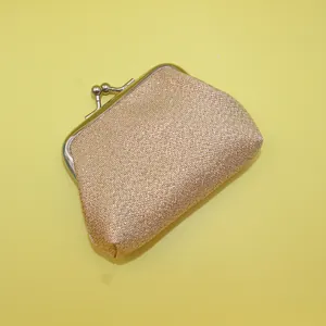 Détail du tissu à paillettes dorées avec fermoir en métal argenté classique sur mini bourse